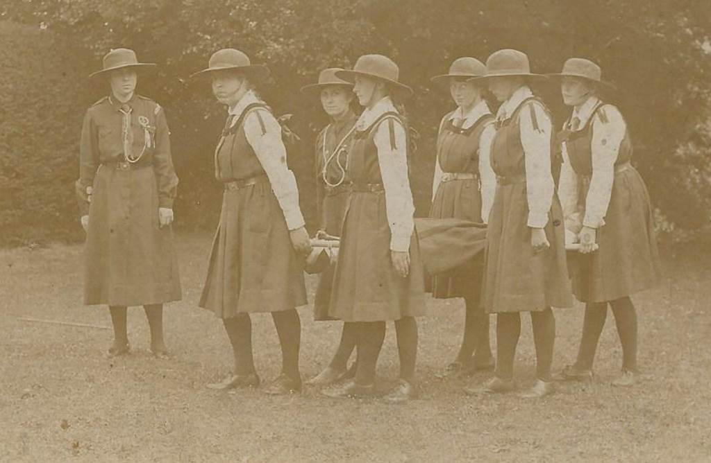 A group of women standing in front of a bench

Description automatically generated