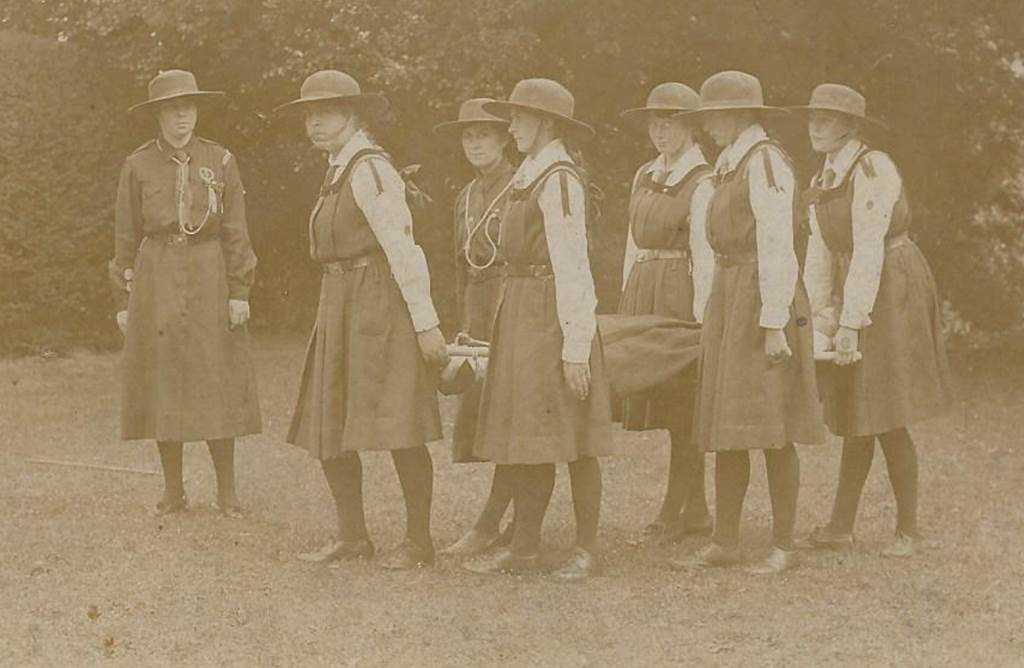 A group of women standing in front of a bench

Description automatically generated