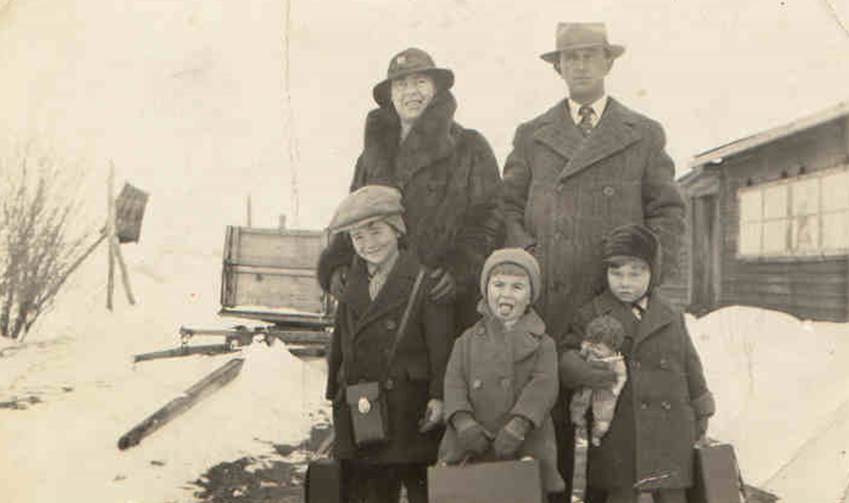 A family posing for a photo in the snow

Description automatically generated