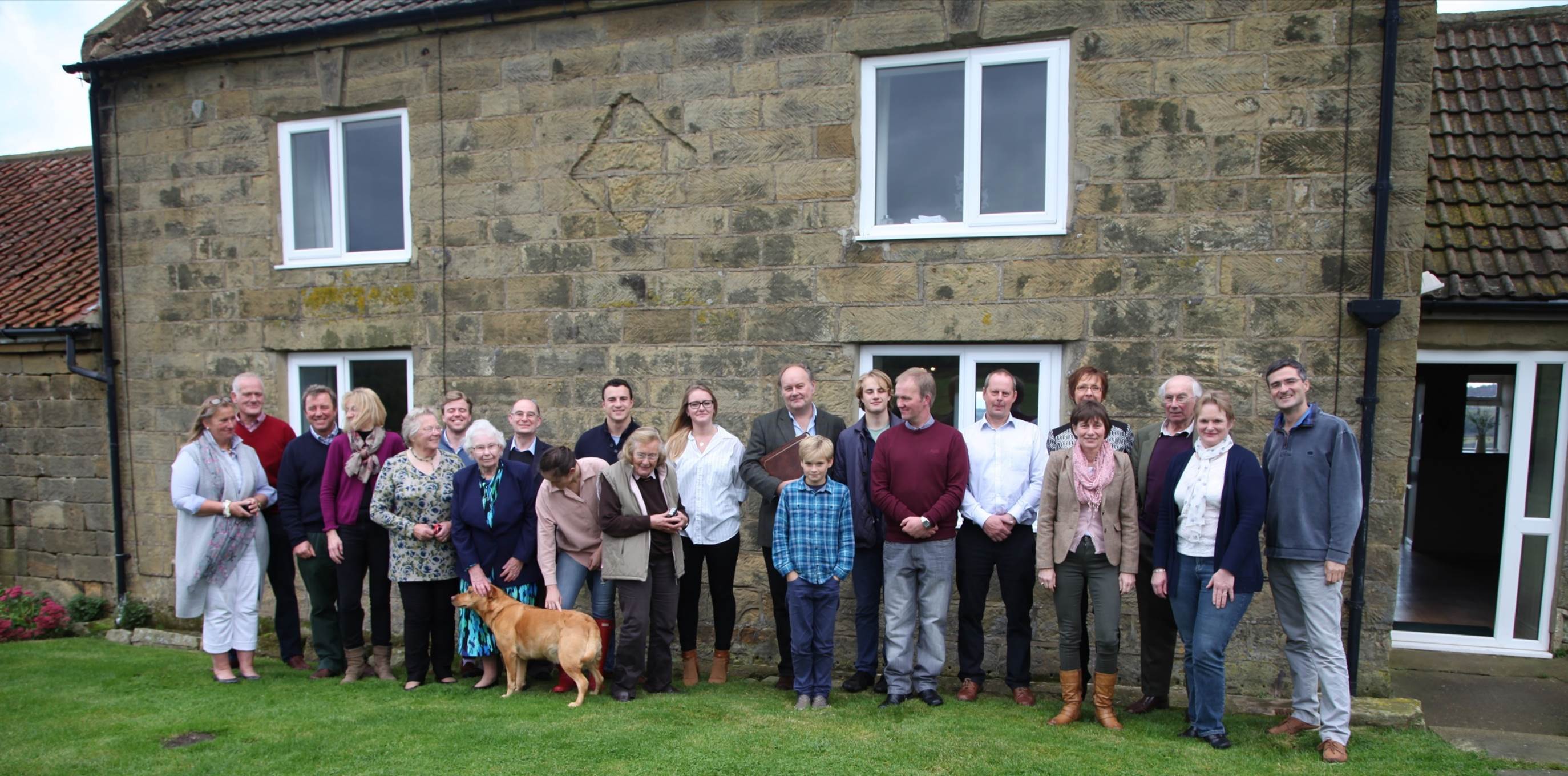 A group of people standing in front of a building

Description automatically generated