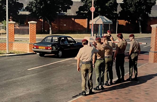 A group of men saluting on the street

Description automatically generated