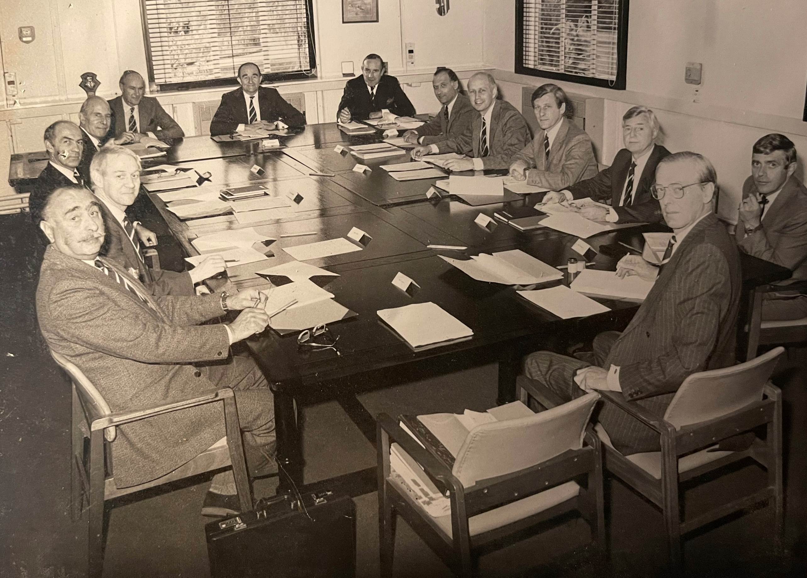 A group of men sitting around a table

Description automatically generated