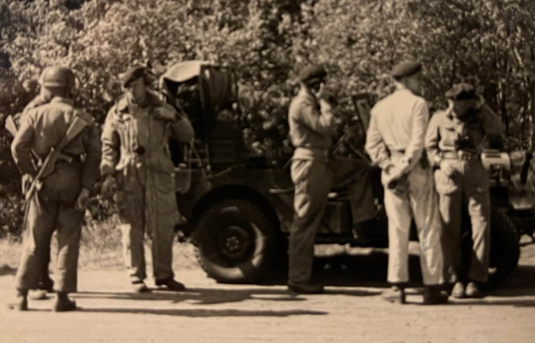 A group of men standing next to a car

Description automatically generated with low confidence