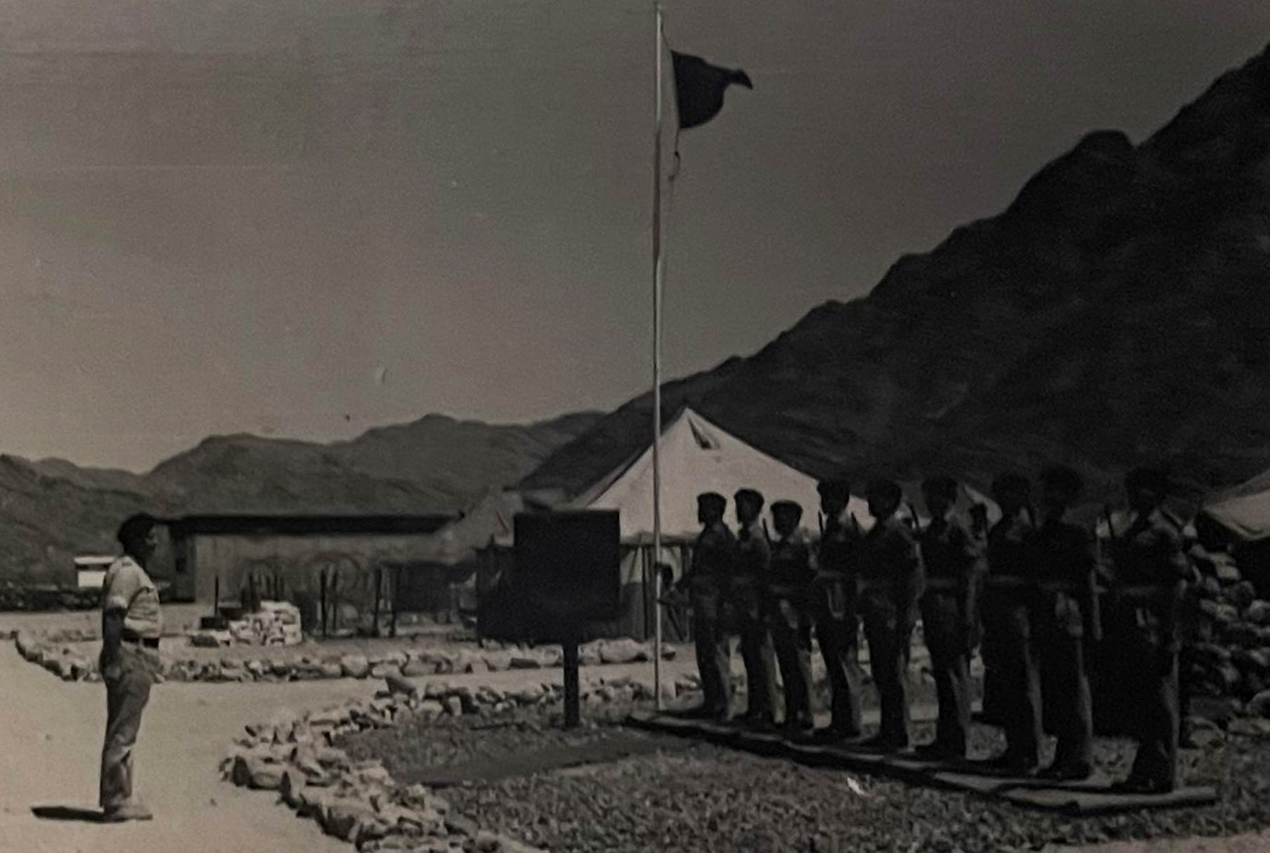 A group of people standing next to a flag on a pole

Description automatically generated with medium confidence