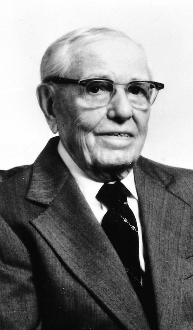 A vintage photo of a person in a suit and tie

Description automatically generated