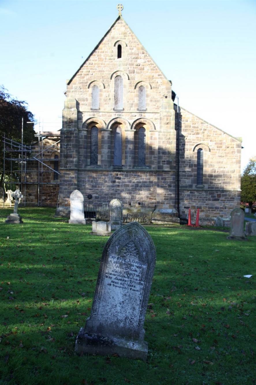 A stone monument in front of a building

Description automatically generated