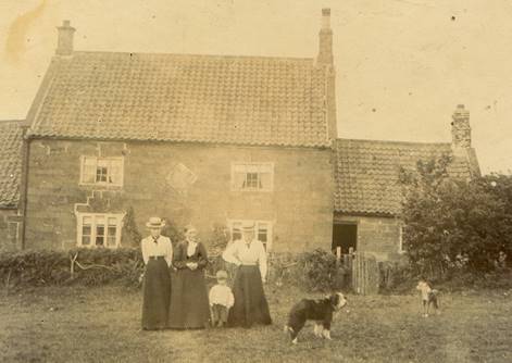 A family standing in front of a house

Description automatically generated