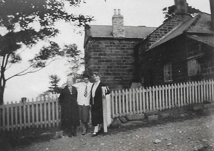 A black and white photo of a person walking by a fence

Description automatically generated