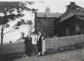 A black and white photo of a person walking by a fence

Description automatically generated