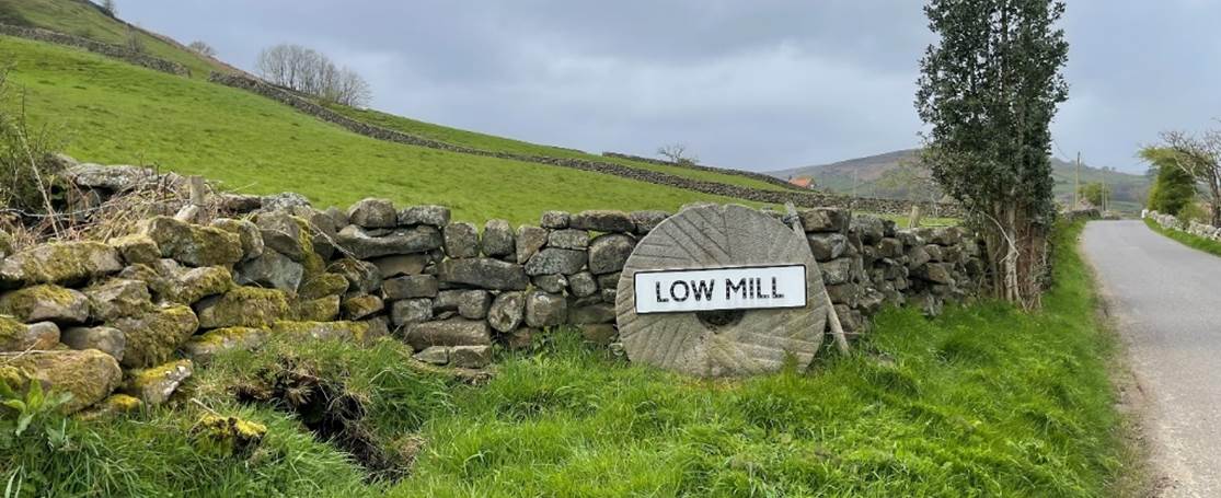 A stone wall with a sign on it

Description automatically generated