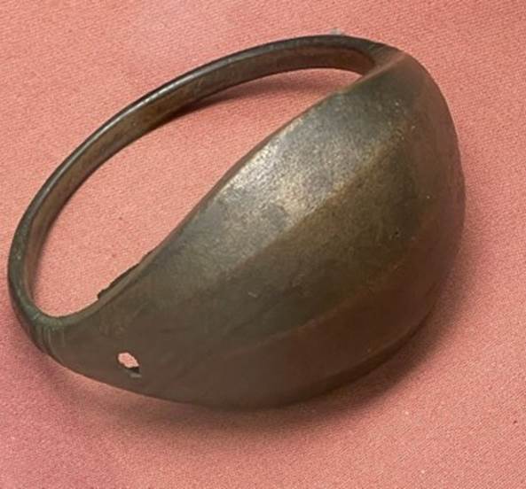 A metal ring on a pink surface

Description automatically generated