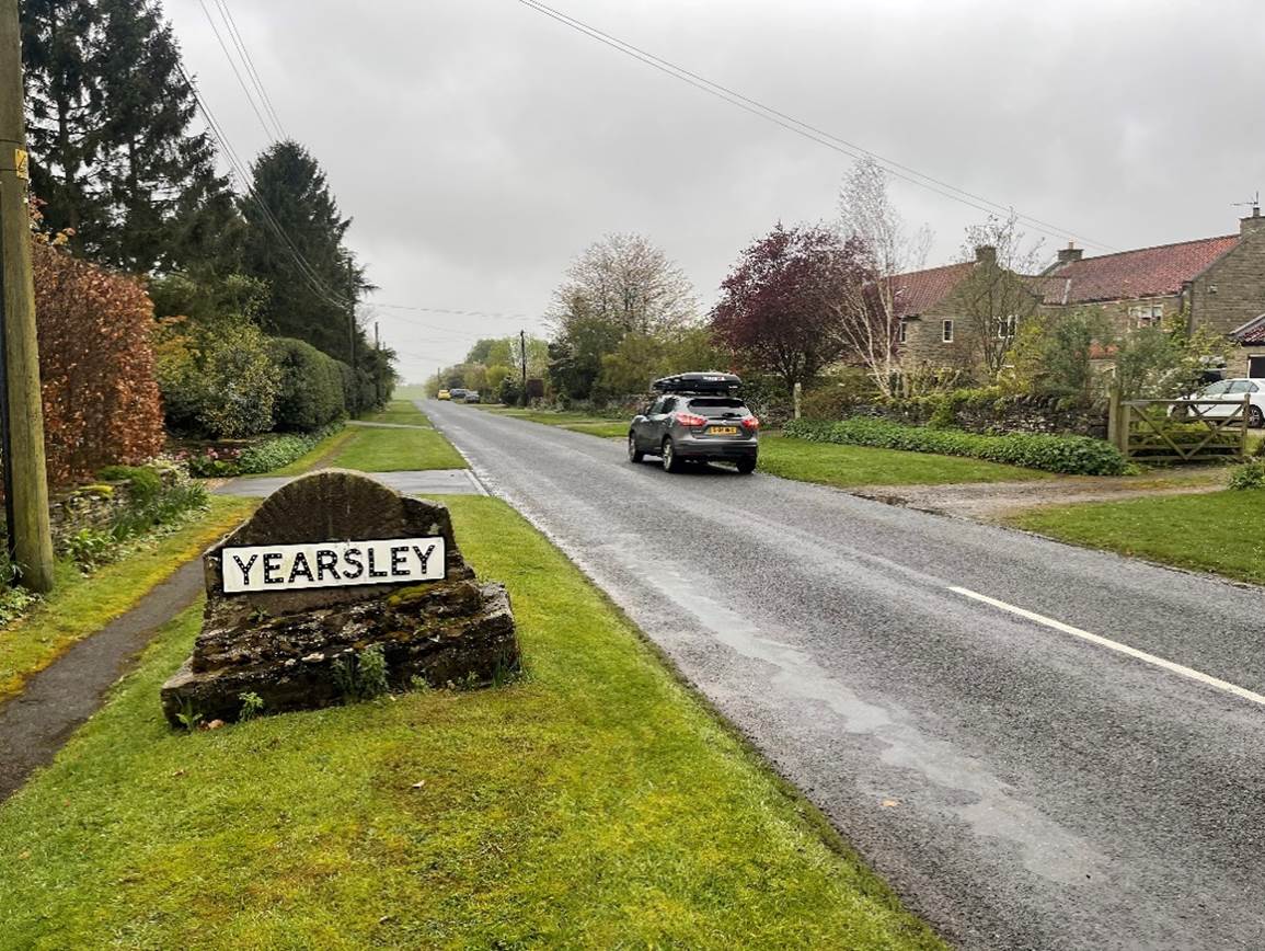 A road with a sign on it

Description automatically generated