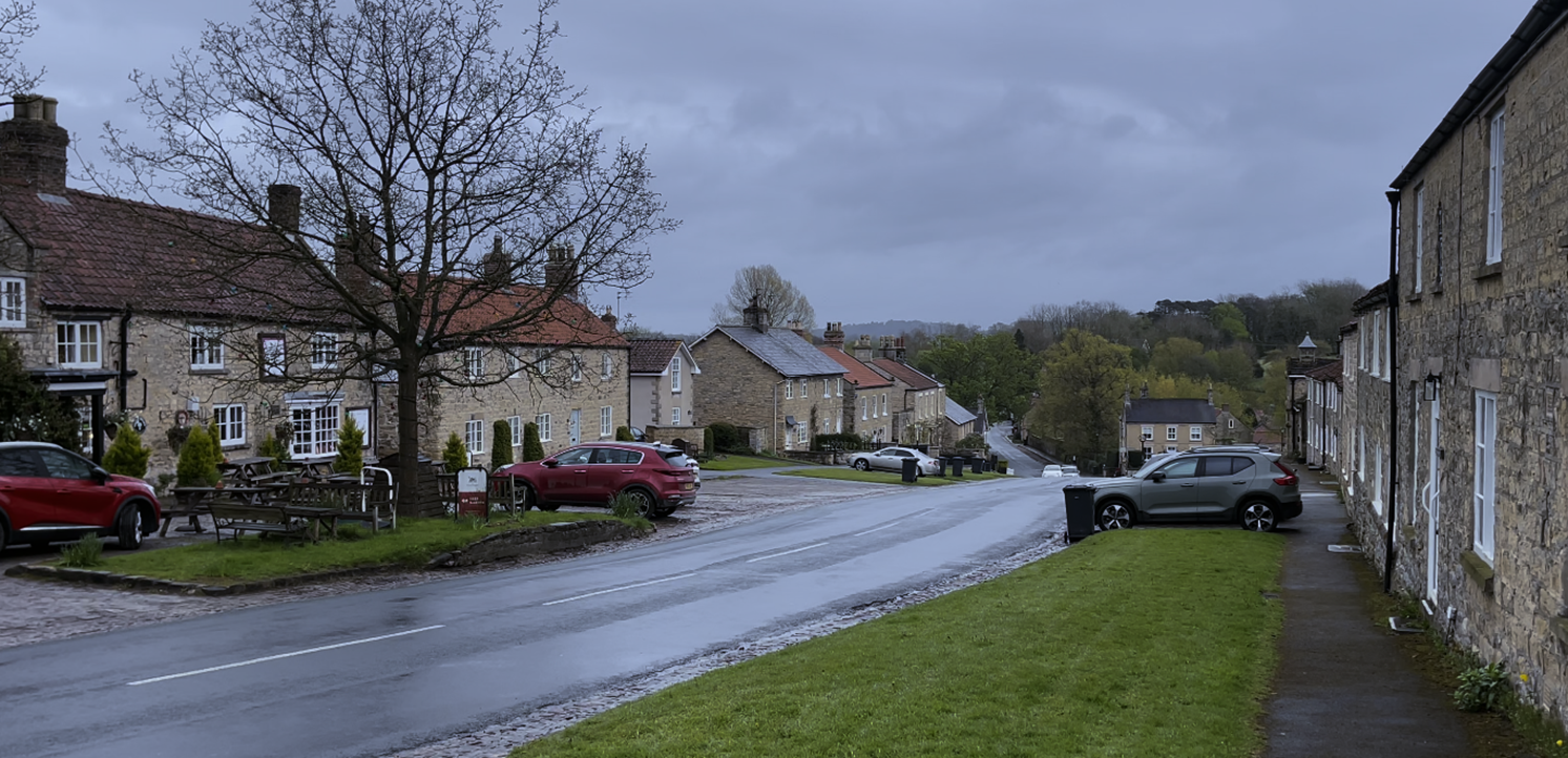 A road with cars parked on it

Description automatically generated