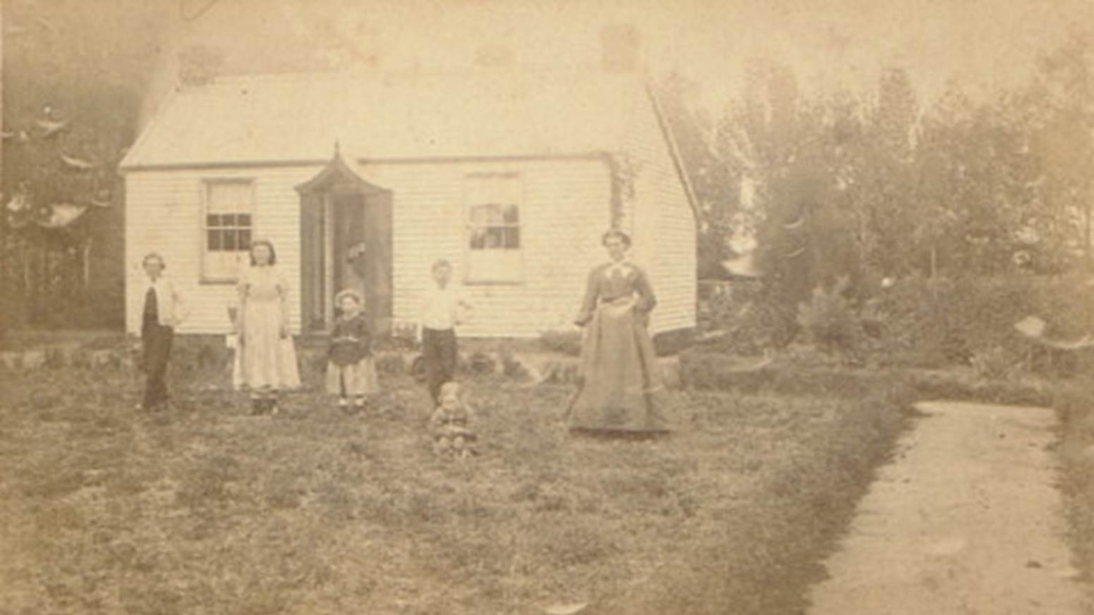 A group of people standing in front of a house

Description automatically generated