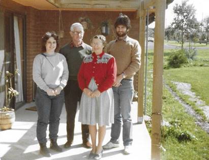 A group of people standing on a porch

Description automatically generated