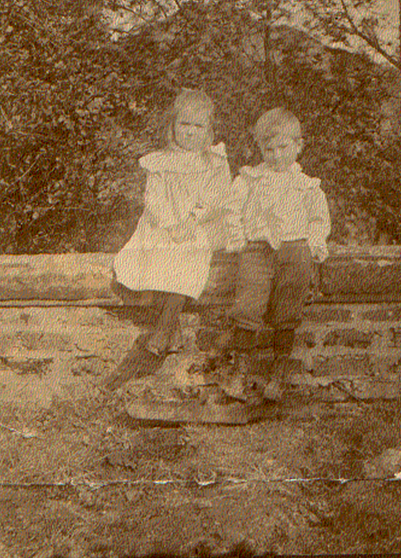 A couple of children sitting on a log

Description automatically generated