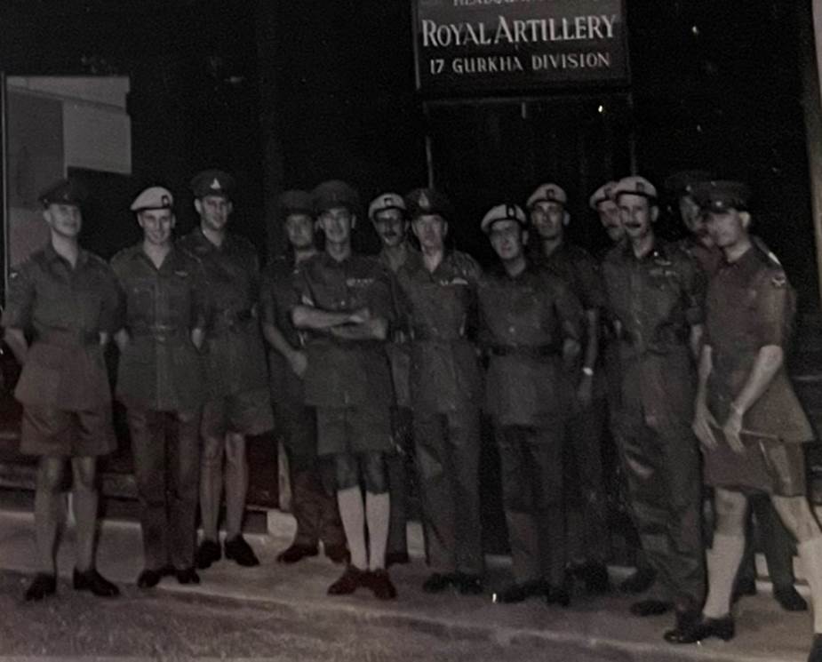 A group of people in uniform standing on the street

Description automatically generated