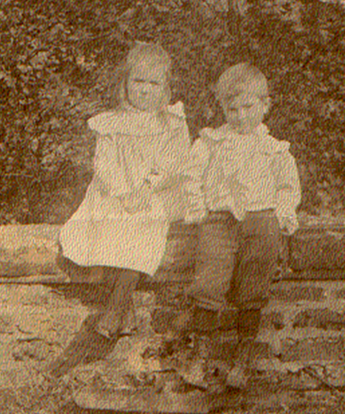 A couple of children sitting on a log

Description automatically generated