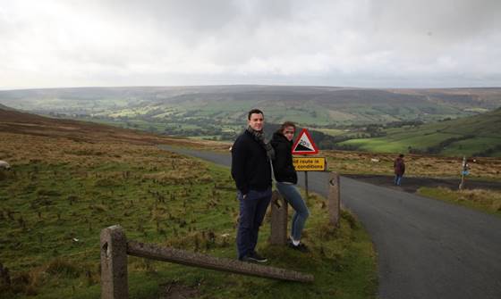 A person and person standing on a road

Description automatically generated