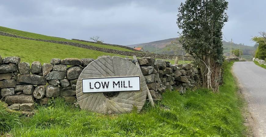 A stone wall with a sign on it

Description automatically generated