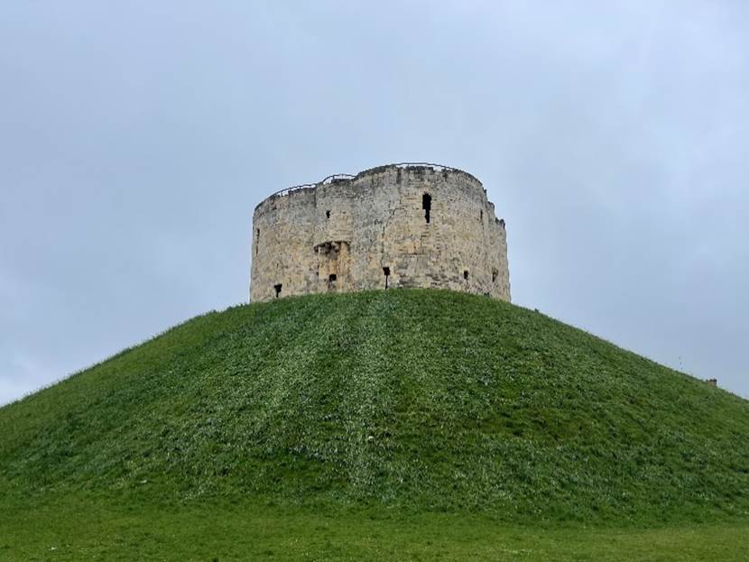 A stone tower on a hill

Description automatically generated