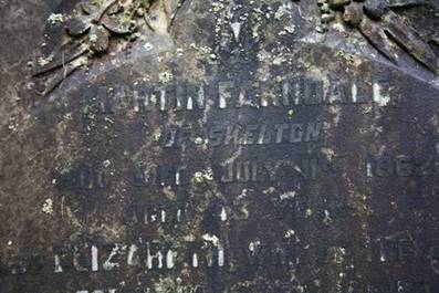 Close-up of a tombstone with engraved text

Description automatically generated