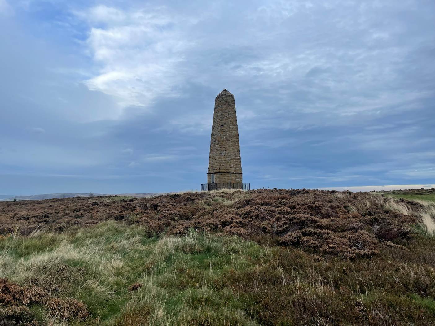 A stone tower in a field

Description automatically generated