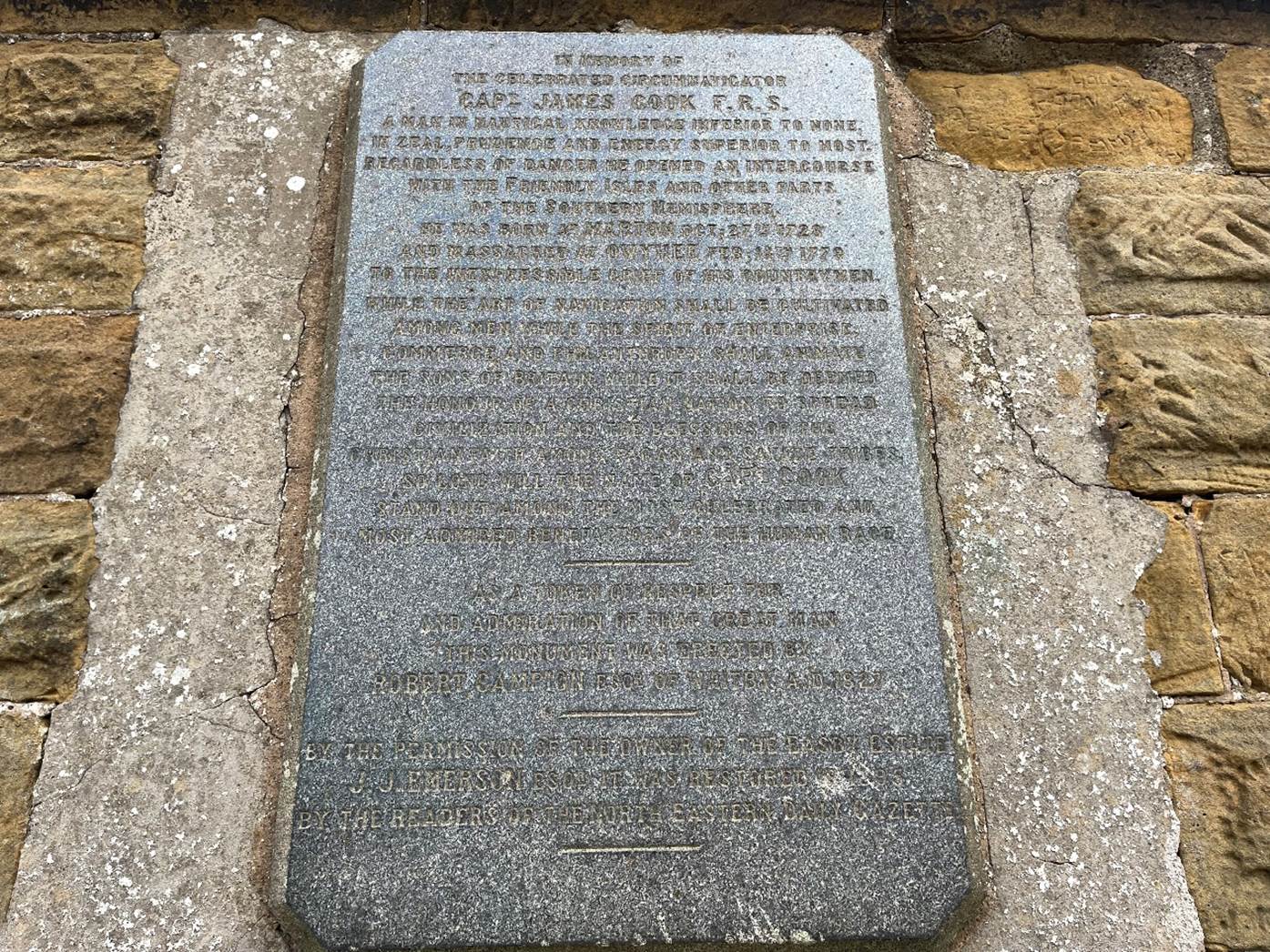 A stone with text on it

Description automatically generated