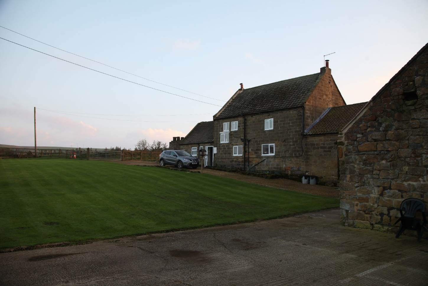 A house with a lawn and a car parked in front of it

Description automatically generated