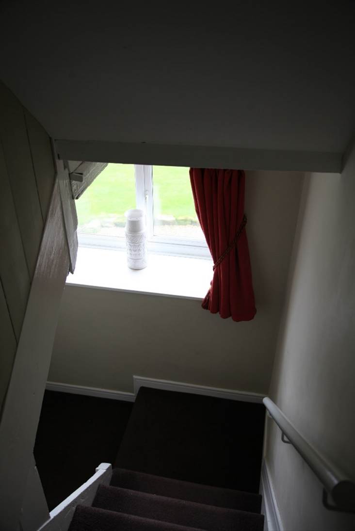 A red curtain on a window sill

Description automatically generated