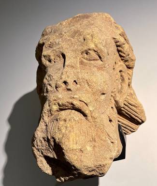 A stone sculpture of a person's face

Description automatically generated