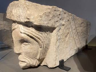 A stone sculpture of a person's face

Description automatically generated