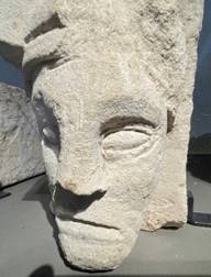 A stone sculpture of a face

Description automatically generated