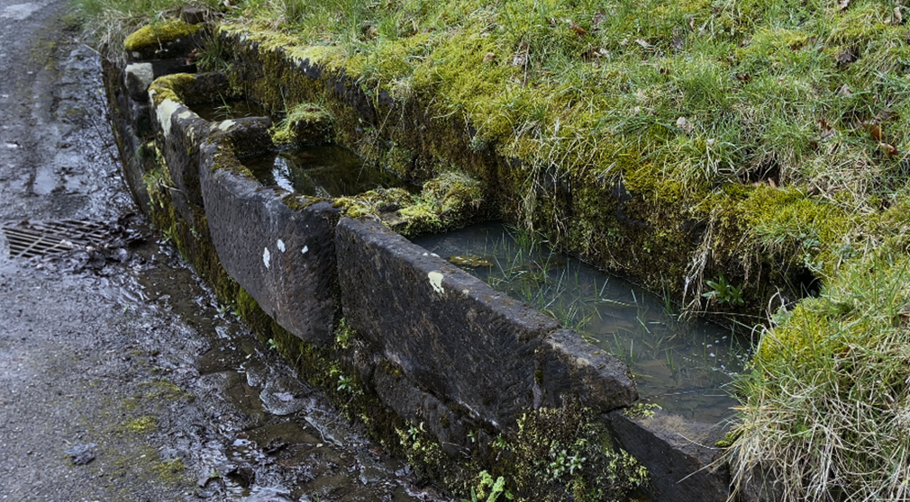 A water flowing through a stone wall

Description automatically generated