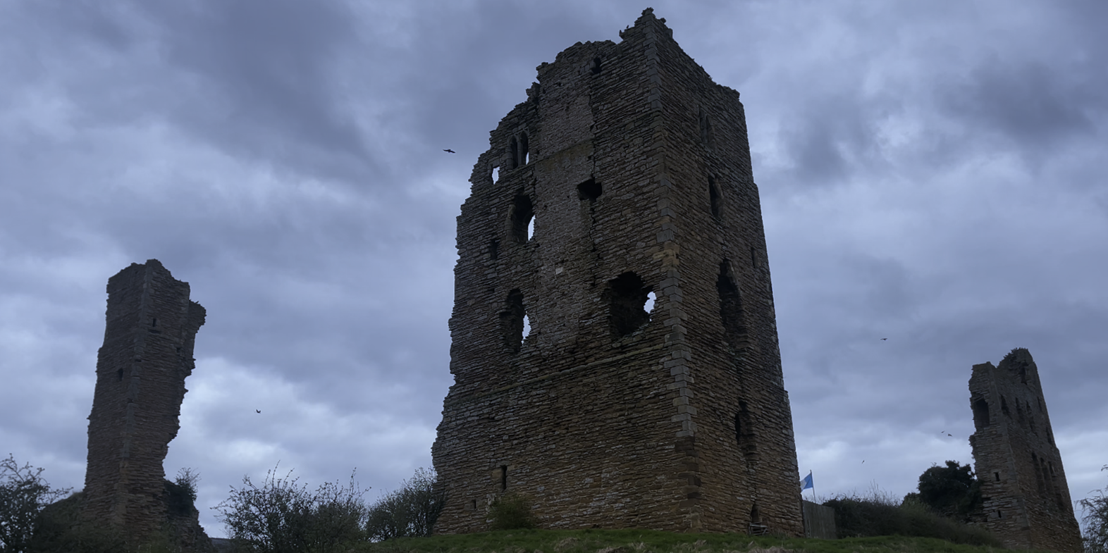 A stone tower with holes in the middle

Description automatically generated