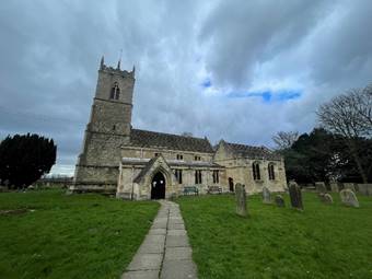 A stone church with a stone tower

Description automatically generated