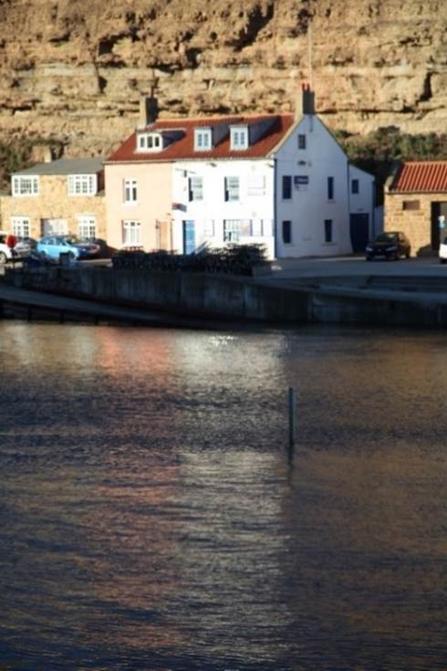 A body of water with a building in the background

Description automatically generated