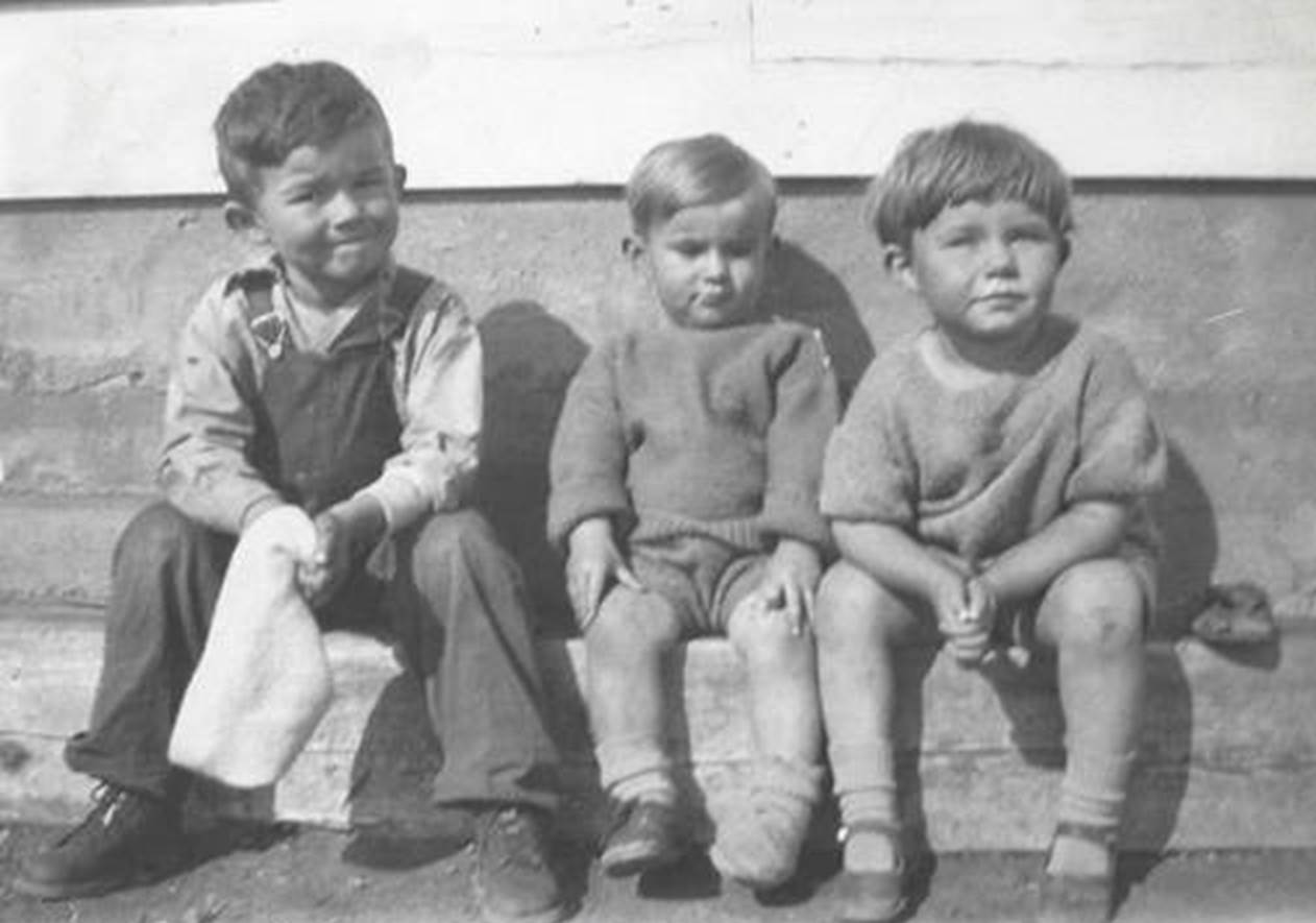 A vintage photo of a group of people posing for the camera

Description automatically generated