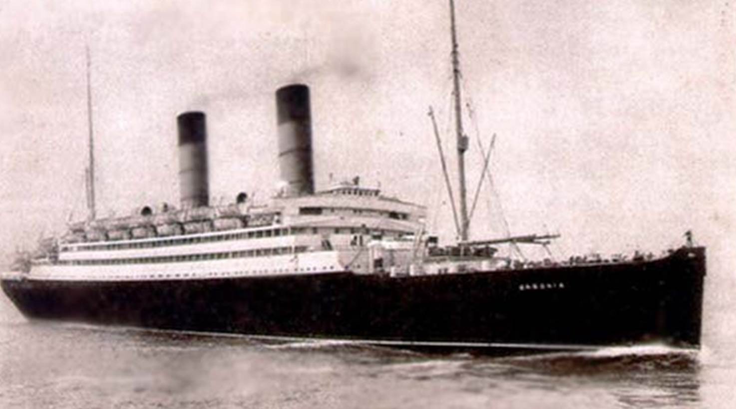 A large ship on the water with RMS Queen Mary in the background

Description automatically generated