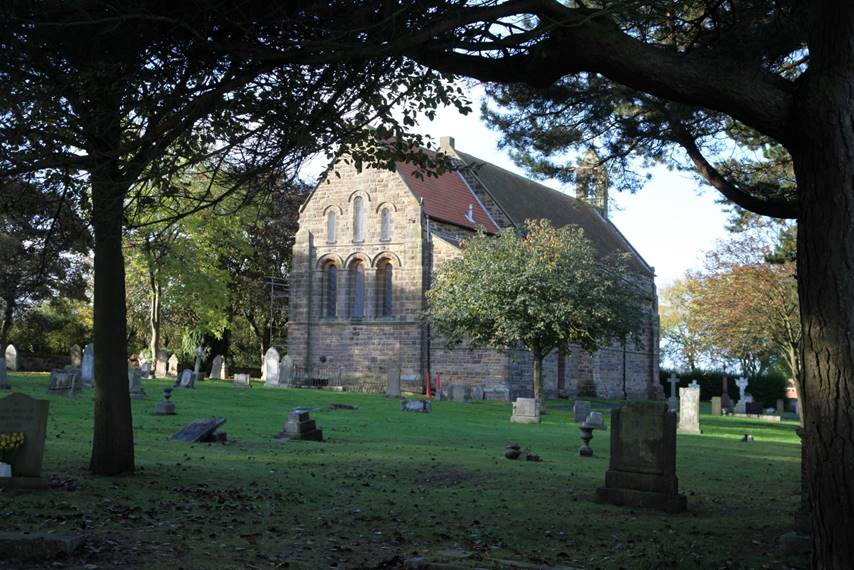 A stone building with a cemetery

Description automatically generated