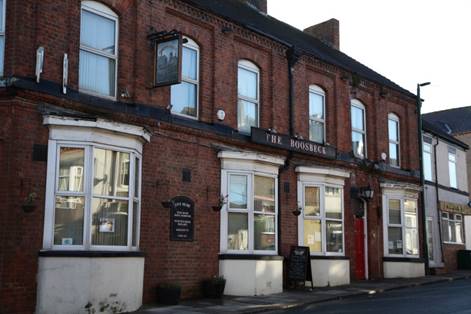 A brick building with white windows

Description automatically generated