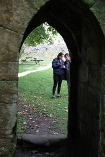 A group of people standing in a stone archway

Description automatically generated