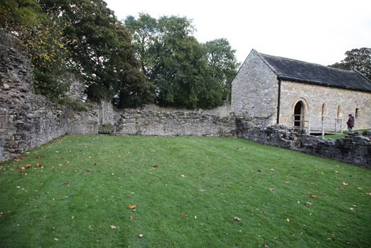 A stone building with a green lawn

Description automatically generated