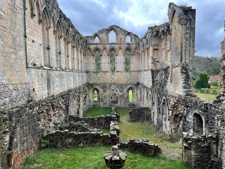 An old stone building with a green lawn with Wolvesey Castle in the background

Description automatically generated with medium confidence