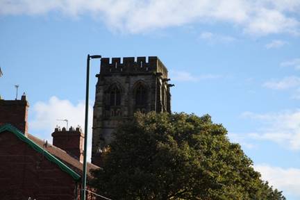 A stone tower with a tree in the background

Description automatically generated