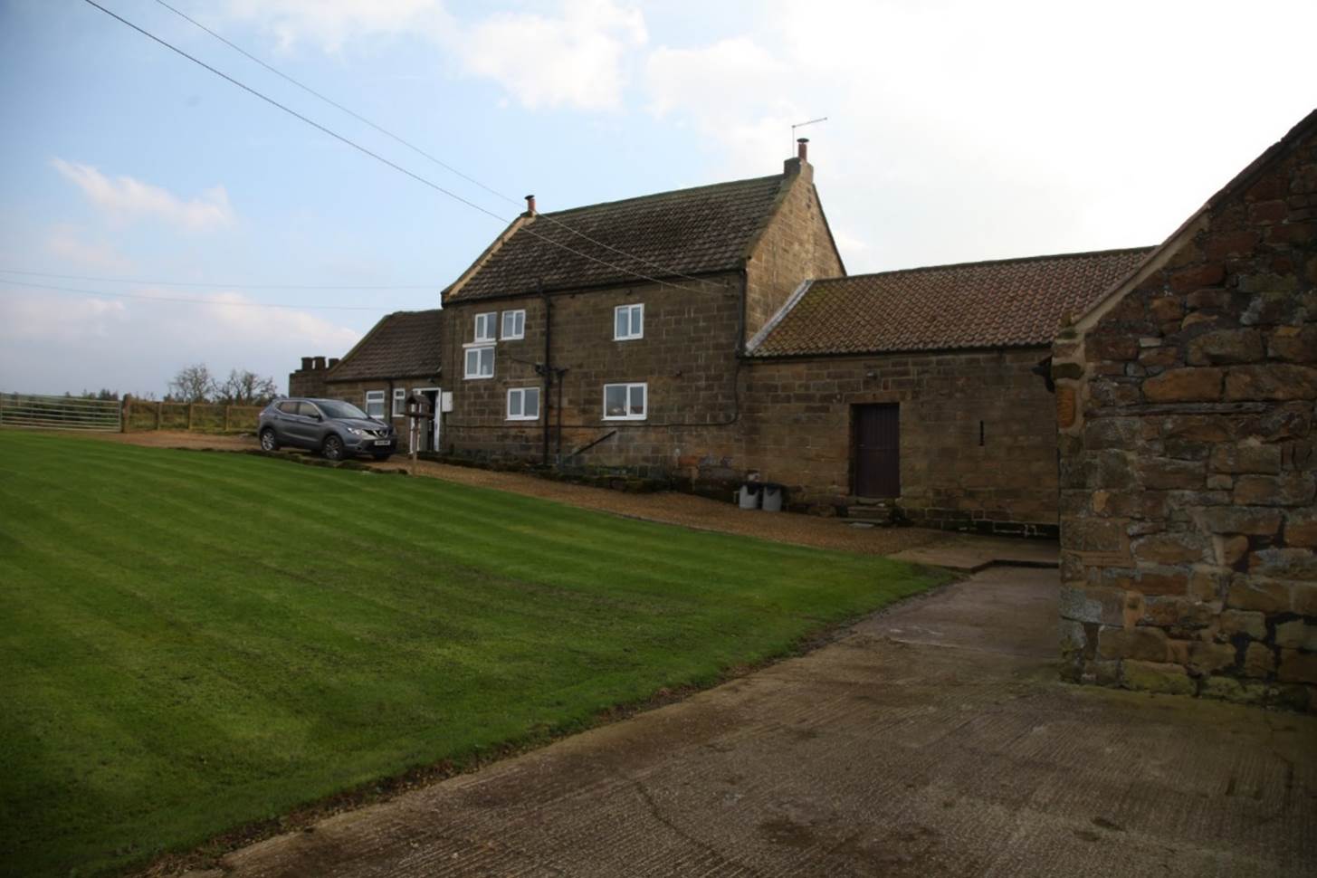 A house with a lawn and a car parked in front of it

Description automatically generated