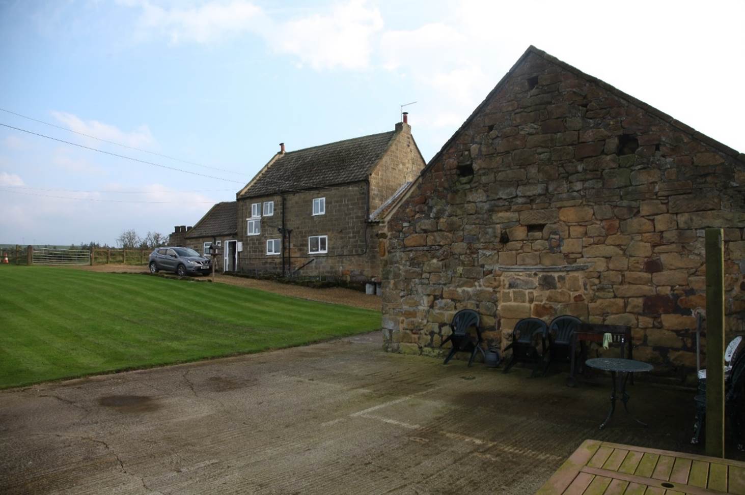 A stone house with a lawn

Description automatically generated