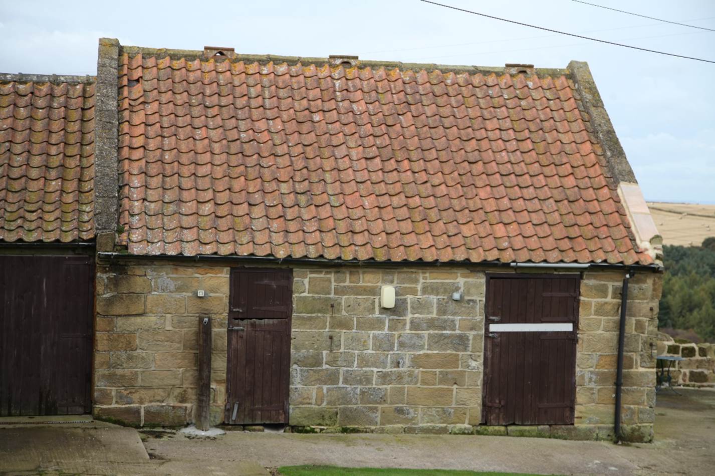 A stone building with a door and a door

Description automatically generated