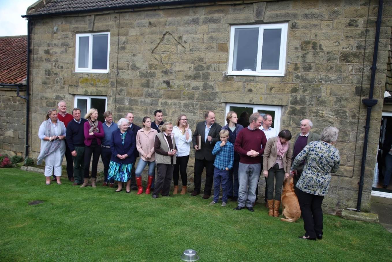 A group of people standing in a line outside a building

Description automatically generated