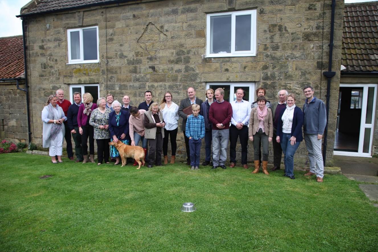 A group of people standing in front of a building

Description automatically generated